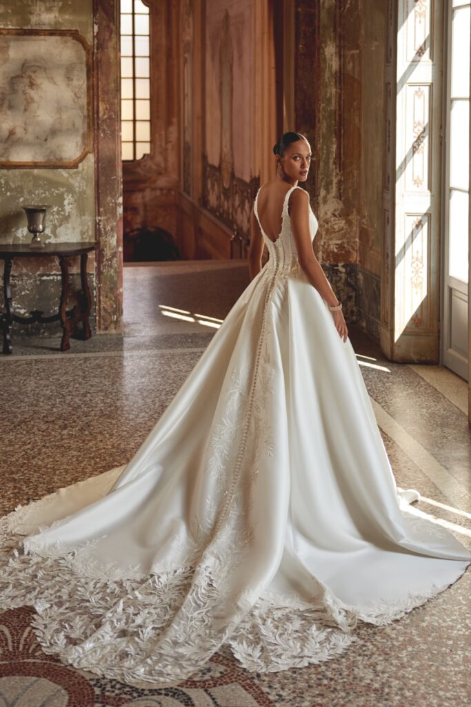 abito sposa scollato nella schiena e gonna principesca con coda e bottoncini di justin alexander a parma da effetto sposa atelier